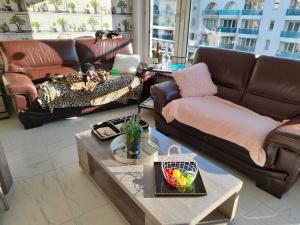 a living room with leather couches and a coffee table at Superbe appartement à koksijde (coxyde) in Koksijde