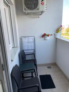 Zimmer mit 2 Stühlen, einem Ventilator und einem Fenster in der Unterkunft Gordana Apartments in Belgrad