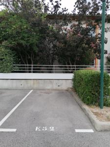 un aparcamiento vacío con una valla y árboles en Les Portes du Soleil, en Grabels