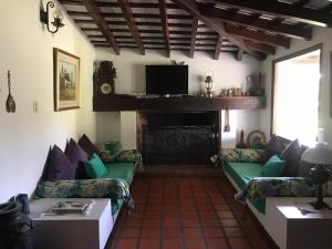 sala de estar con 2 sofás y chimenea en Campo Las Marias en Santa Catalina