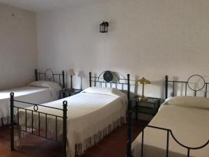 1 dormitorio con 2 camas y 2 mesas con lámparas en Campo Las Marias en Santa Catalina