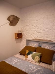um quarto com uma cama com duas almofadas em Studio Le chat’Oh! em Combourg
