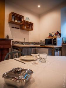 uma cozinha com uma mesa com um prato e copos em Studio Le chat’Oh! em Combourg