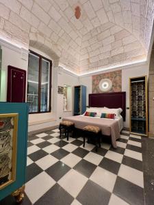 - une chambre avec un lit et un sol en damier dans l'établissement Incentro Domus, à Polignano a Mare