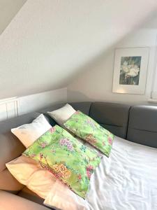 a bed with three pillows on top of it at Sonnige Wohnung am Lindenberg in Lohfelden