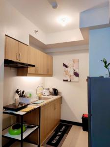 a kitchen with wooden cabinets and a blue refrigerator at VERDON PARC CONDOMINIUM in Davao City