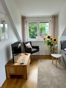 a living room with a couch and a table with a tv at Sonnige Wohnung am Lindenberg in Lohfelden