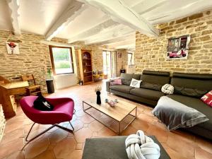 sala de estar con sofá y silla roja en Gîte Diamant, Vallée du Scorff, Nature, Bien-être en Arzano