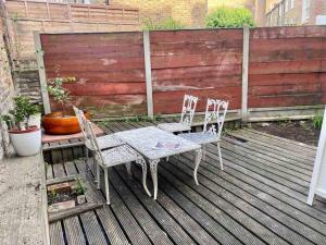 una mesa y sillas sentadas en una terraza en Cosy Studio in trendy Islington, w/private garden!, en Londres