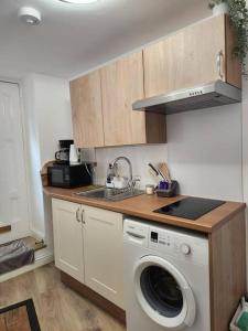 cocina con fregadero y lavadora en Cosy Studio in trendy Islington, w/private garden!, en Londres