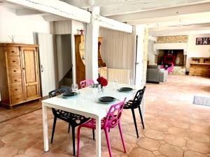 a table with four chairs and a white table with flowers on it at Gîte Diamant, Vallée du Scorff, Nature, Bien-être, 6 personnes in Arzano
