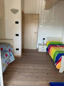 a bedroom with two beds and a wooden floor at Mansarda Cimbra in Folgaria