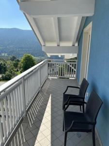 two chairs sitting on the balcony of a house at Mansarda Cimbra in Folgaria +4 photos