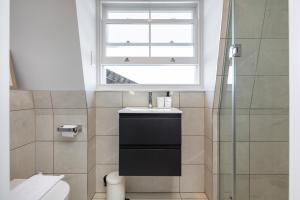 baño con lavabo y ventana en Notting Hill Apartments Collection en Londres