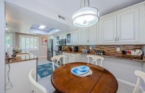 a kitchen with a wooden table and white cabinets at Sonrisa 1 in Clearwater Beach