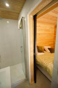 Dormitorio pequeño con cama y ducha en Cabane forêt proche plage en Pyla-sur-Mer