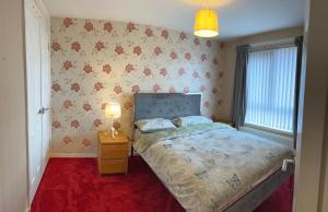 a bedroom with a bed and a red carpet at 3 Bedroom House near city centre in Belfast