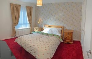 a bedroom with a bed with a large headboard at 3 Bedroom House near city centre in Belfast