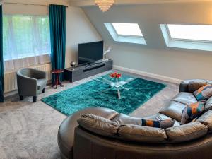 a living room with a couch and a table at The Gables Poole, 3 Bedroom Penthouse Apartment in Poole