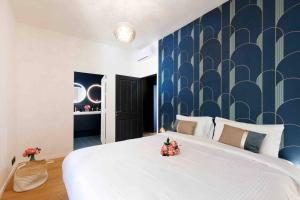 ein Schlafzimmer mit einem großen weißen Bett und einer blauen Wand in der Unterkunft Belvedere - Villa Luxe Montfleury in Cannes