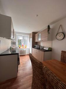 a kitchen with a table and chairs and a clock on the wall at Apartman centrum Šturka in Martin