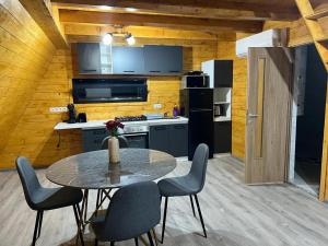 eine Küche mit einem Tisch und Stühlen im Zimmer in der Unterkunft Little House Bologa in Bologa