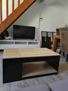 sala de estar con TV y mesa en appartement duplex en Beaune-la-Rolande