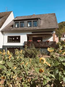 a house with a field of sunflowers in front of it at Ferienwohnung Moselflair mit direktem Blick auf die Mosel und Weinberge in Oberfell