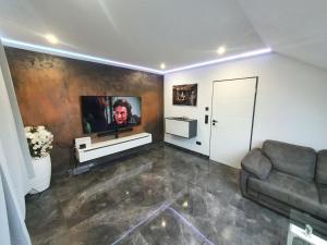 ein Wohnzimmer mit einem Sofa und einem TV an der Wand in der Unterkunft Los Angeles Apartment in Paderborn