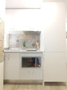 a white kitchen with a stove and a microwave at Alicante Alive -Jorge Juan in Alicante