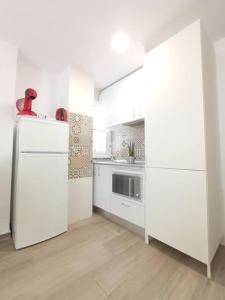 a kitchen with white cabinets and a refrigerator at Alicante Alive -Jorge Juan in Alicante