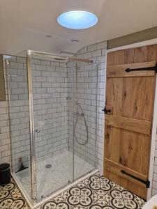 a shower with a glass door in a bathroom at Idyllic period cottage, Ramsbury, Nr Marlborough in Ramsbury
