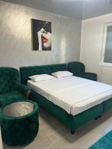 een slaapkamer met een bed en een groene bank bij Sipotul Apelor in Domneşti