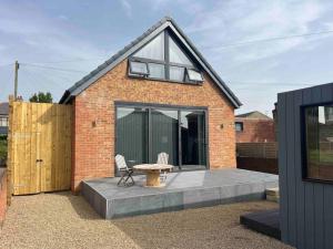 a brick house with a table and two chairs at The pump house hot tub retreat outskirts of leeds in Leeds