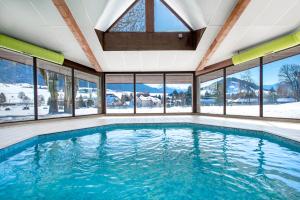 a swimming pool in a house with windows at L'ESCANDILLE Village Vacances in Autrans