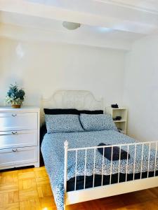 - une chambre avec un lit blanc et une commode blanche dans l'établissement Stylish Montreal Apartment: Comfortable Stay in the Golden Square Mile, à Montréal