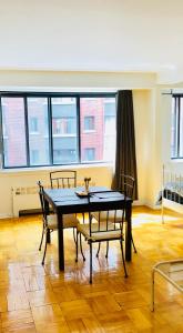 - une salle à manger avec une table, des chaises et des fenêtres dans l'établissement Stylish Montreal Apartment: Comfortable Stay in the Golden Square Mile, à Montréal