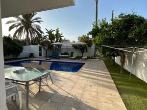patio con tavolo e piscina di Villa Victoria a Larnaka