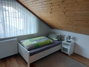 a bed in a small room with a window at Moderne Ferienwohnung - neu renoviert - ruhige Lage in Waldachtal