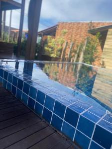 a swimming pool with blue tiles on top of it at Cabana do Embaú Experience in Palhoça