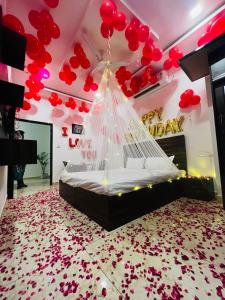a bedroom with a bed with red balloons on the ceiling at Hotel Homeland Inn in Sirsa