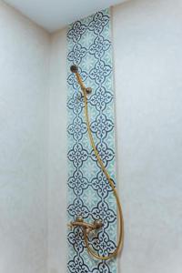 uma gravata pendurada numa parede com um papel de parede em Auberge RIAD DLIM Tamraght em Tamraght Ouzdar
