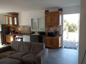 a living room with a couch and a kitchen at Location avec piscine Sud Ardèche in Berrias Et Casteljau