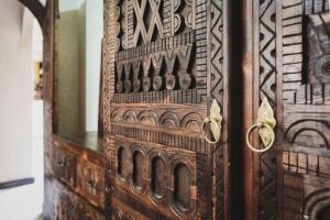 een oude houten deur met een ontwerp erop bij Auberge RIAD DLIM Tamraght in Tamraght Ouzdar