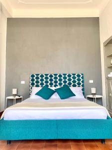 1 cama con cabecero azul y 2 almohadas en Upi-Up Rome Staying en Roma
