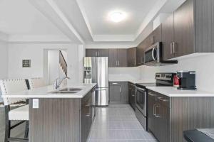a kitchen with stainless steel appliances and wooden cabinets at Enchanted escape in Welland