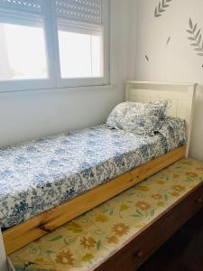 1 cama en un dormitorio con 2 ventanas en DEPARTAMENTO 3 AMBIENTES ZONA PLAYA GRANDE en Mar del Plata