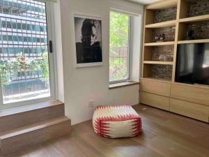 uma sala de estar com televisão e um repousa-pés em Superb Duplex Penthouse in FIDI em Nova York