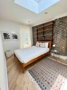 um quarto com uma cama grande e uma parede de tijolos em Superb Duplex Penthouse in FIDI em Nova York