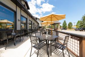 an outdoor patio with tables and chairs with umbrellas at MTN Lodge Ridgway in Ridgway
